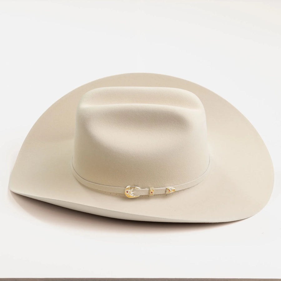 Sombrero vaquero Larry Mahan blanco, visto de frente, con copa moldeada y detalle metálico.