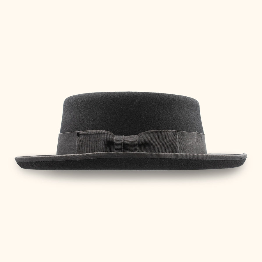 Sombrero pork pie La Nutria oscuro, visto de lado; destaca el lazo de la cinta