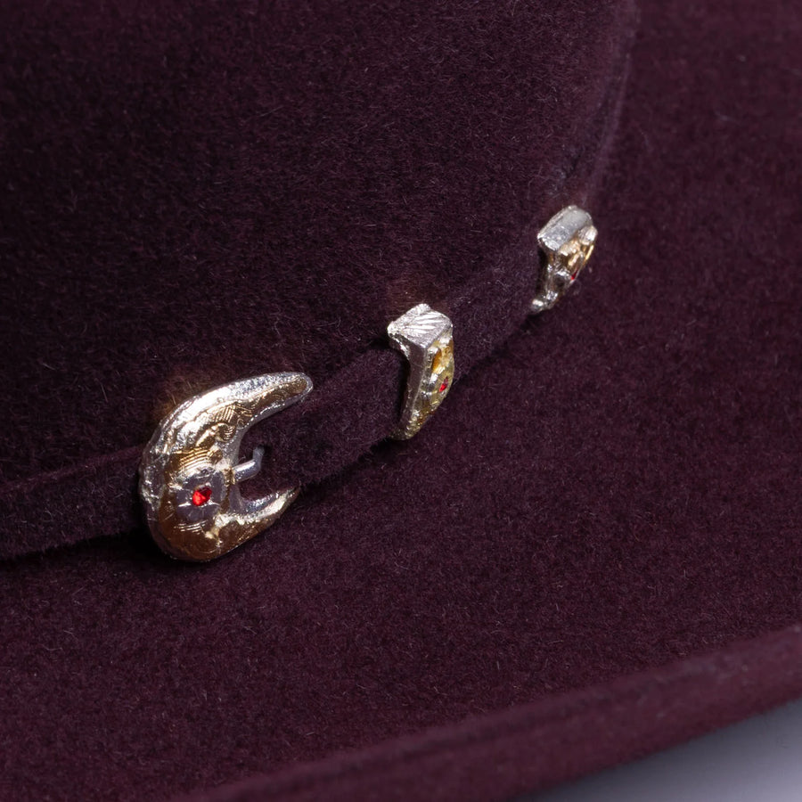 Detalle de adornos metálicos con piedras en la banda del sombrero Larry Mahan borgoña