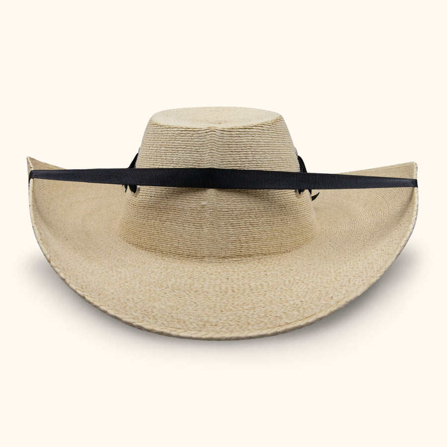 Sombrero de paja beige con copa alta y banda negra alrededor del ala